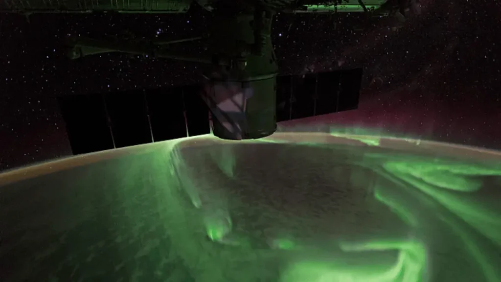 Aurora Australis over Earth's southern hemisphere, captured by an astronaut from the International Space Station, showing lights similar to those seen on Ganymede's poles.